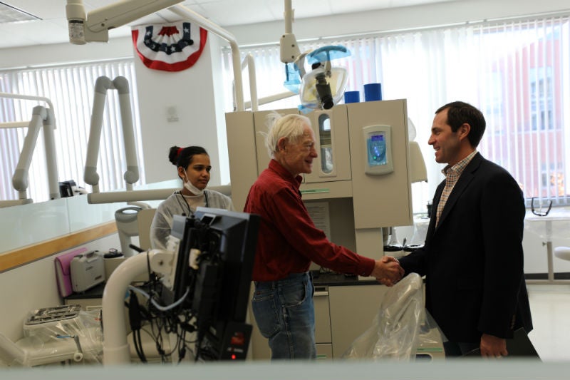 Congressman Jason Crow speaks with a veteran who receives care at the Heroes Clinic at CU School of Dental Medicine