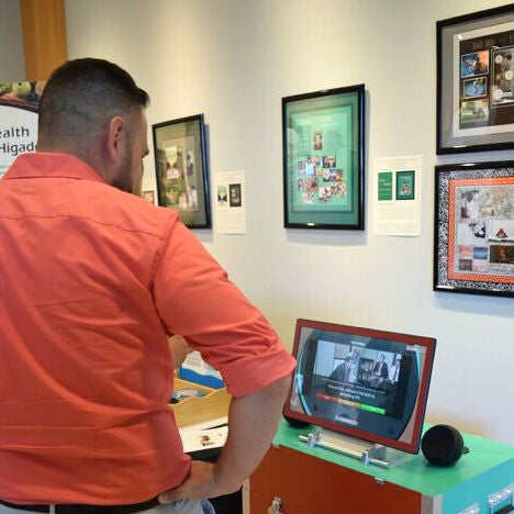 An attendee looks at AHEC information at the Discover Health/Descrube la Salud kickoff event