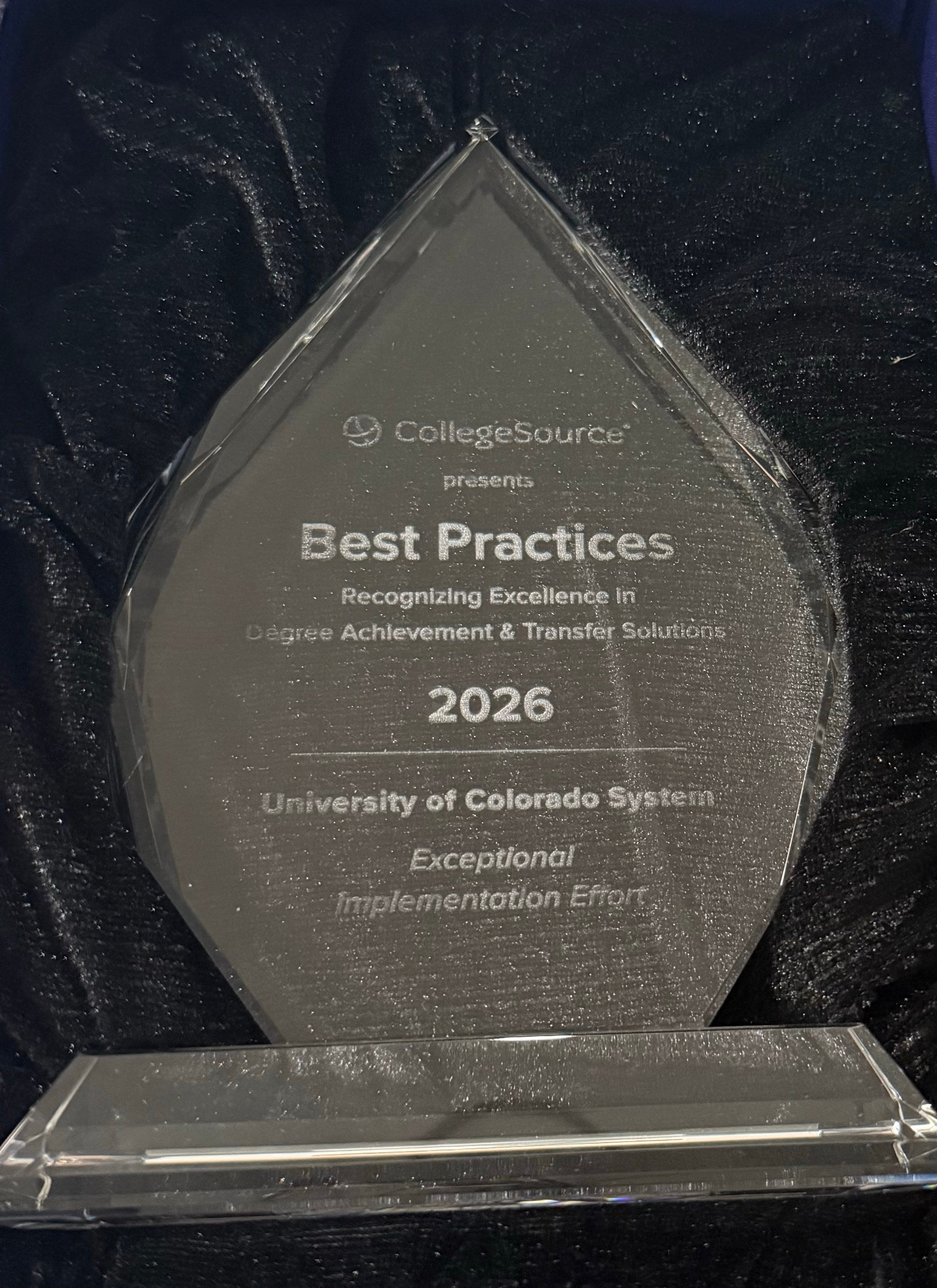 A glass trophy for the 2026 Best Practices award, addressed to University of Colorado System.