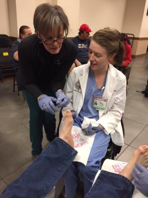 Jane Kass-Wolff, left, helps guide a student volunteer