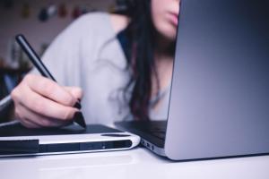 Woman is working at a computer and tablet