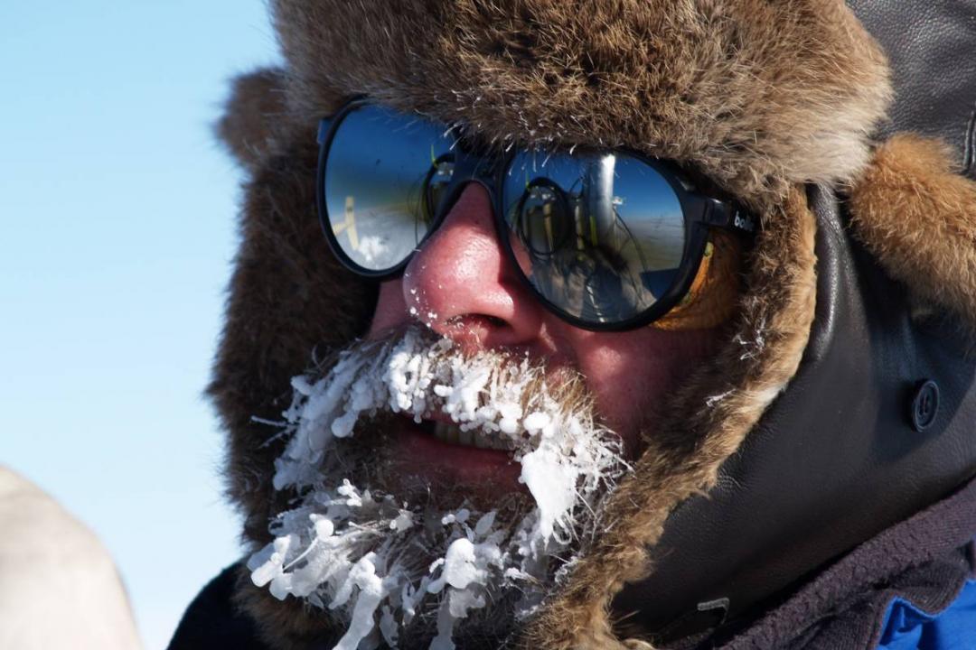 Konrad Steffen outside in the snow with sunglasses and ice on his beard