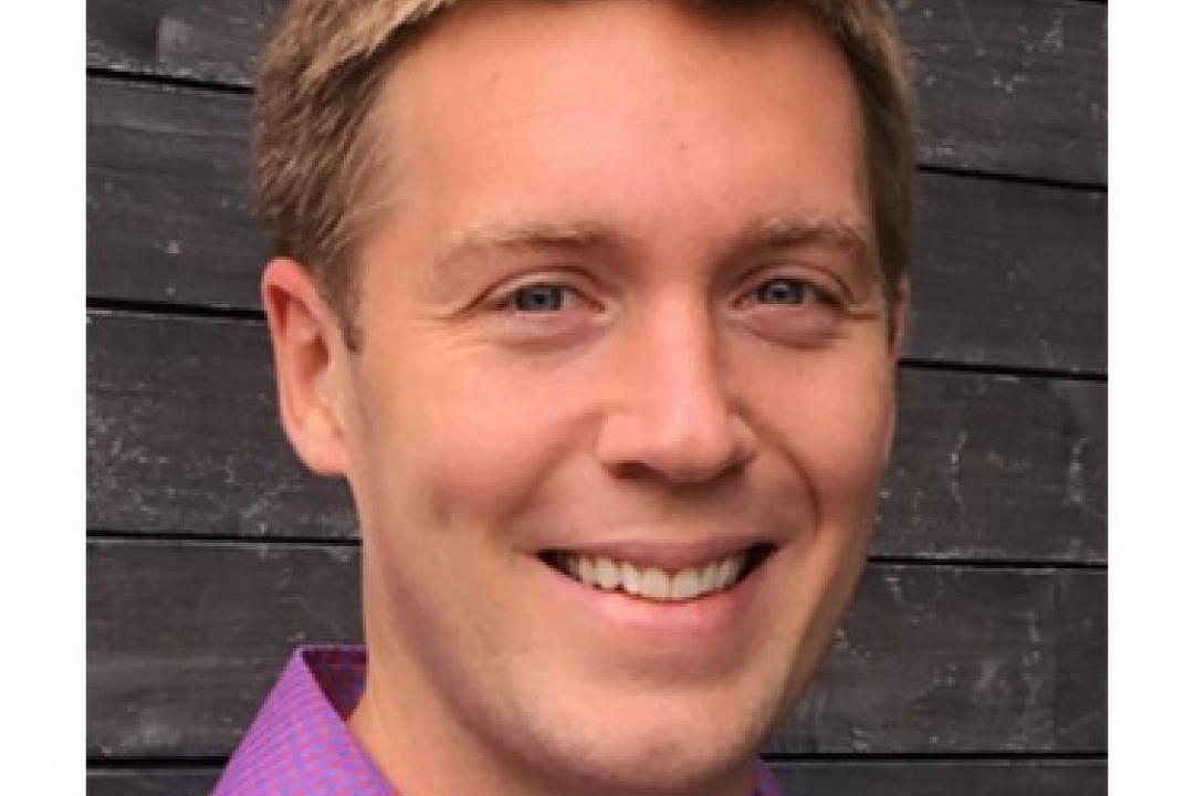Wyatt Shields smiling. He's wearing a light purple collared shirt.