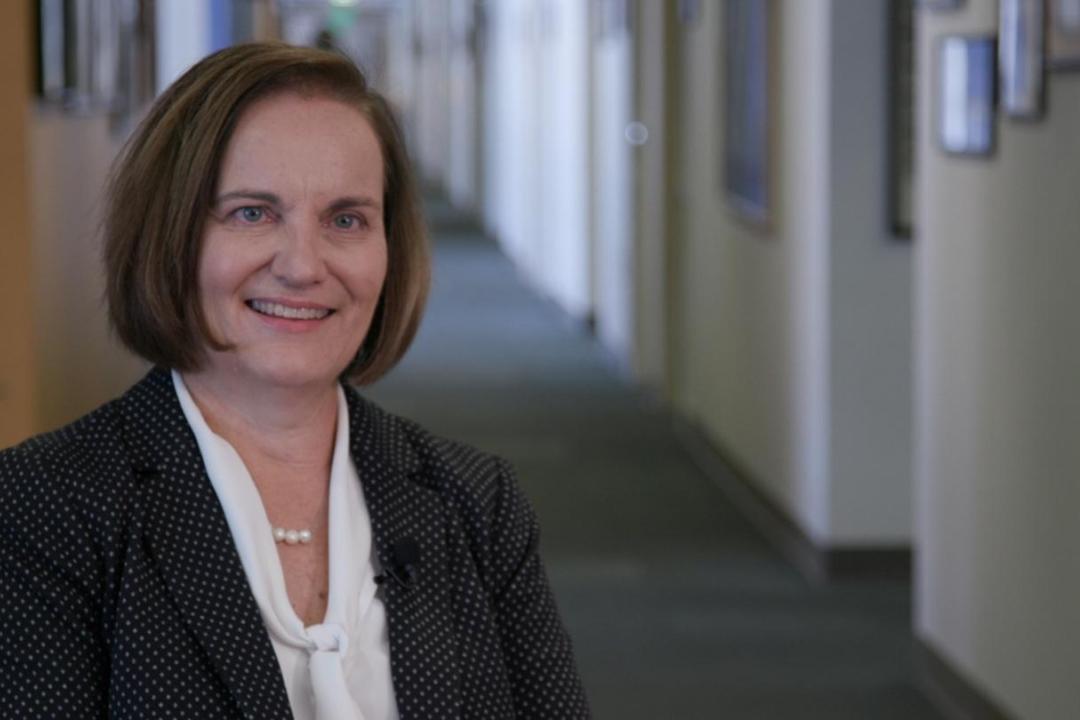 Tammy Spencer smiling in a dark suit jacket and white shirt.