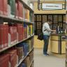 Photo of a student standing at the circulation desk in the UCCS Kraemer Family Library.