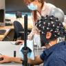 CU Boulder postdoctoral researcher Rosy Southwell and undergraduate student Cooper Steputis demonstrate a functional near-infrared spectroscopy device, which can monitor brain activity.