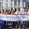 More than a dozen medical professionals stand together holding a sign that reads "Legalize Gay Eyes" in front of the Colorado State Capitol building.