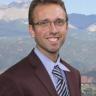 Stephen Cucchiara smiling in a brown suit jacket and blue shirt