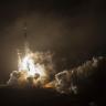 Photo shows the DART rocket launch amid smoke, flames, and a dim background